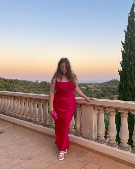 Long haired curvy girl standing on a balcony with a beautiful view of land and the see behind her. Beautiful yellow, rose and blue sunset. She wears a Pink bodycon dress with white high heel sandals and a matching pink bag in her right hand. Pink Bodycon Dress Outfit, Dress For Midsize, Midsize Dresses, Outfit Inspo Midsize, Midsize Summer Outfit, Middy Dress, Bodycon Dress Outfit, Outfit Midsize, Curvy Summer Outfits