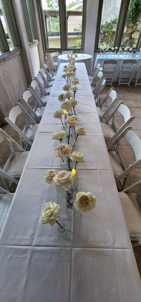 Single Stem Rose Wedding Table, Single Rose Centerpiece With Candles, Simple Rose Table Centerpieces, Bridal Shower Table Center, Single Stem Rose Centerpiece, Single Stem Flower Centerpieces, Single Flower Vases Centerpiece, White Roses Dinner Table, Elegant Bud Vase Centerpiece