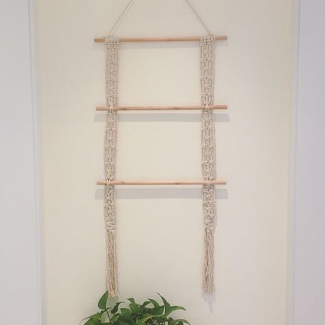 Overview Beautifully hand woven, our Boho Macrame Hanging Ladder adds a delicate and elegant Bohemian accent to your wall. Created with the intention of being both artful and functional, our Hanging Ladder can be used to hang Jewelry, Scarves or other decorative pieces across three wooden dowels. Made of Cotton & W