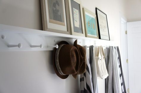 White Shaker Peg Rail with shelf in hallway, straw hats and towels, framed artwork | Remodelista Peg Rails, Shaker Peg Rail, Peg Rail, Shaker Pegs, Coat Pegs, Organized Home, Hallway Storage, Object Lessons, Wooden Pegs