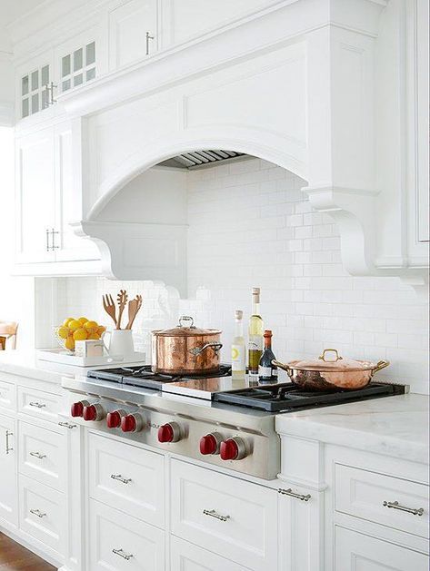 A substantial arch on this range hood presents a classic look. Custom moldings bring even more visual interest, while allowing the hood to meld with the cabinetry. White Cottage Kitchens, Kitchen Hood Ideas, Spanish Style Kitchen, Kitchen Hood Design, Kitchen Vent, Kitchen Range Hood, Cottage Kitchens, Kitchen Hoods, Kitchen Range