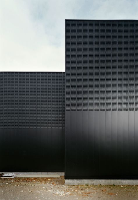 A galvanized steel secondary structure is fixed to this wall, where the steel profiles that complete the ventilated façade are bolted. The profiles are 0,6mm steel sheets, perforated and plain. Black Buildings, Installation Architecture, Black Architecture, Building Skin, Metal Facade, Metal Cladding, Architecture Building Design, Building Facade, Architecture Exterior