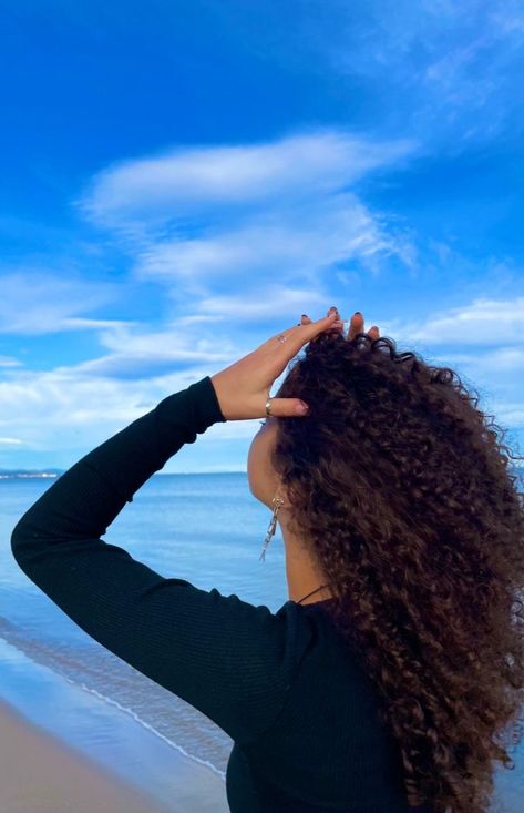 Curly hair girl sitting on the beach with brownish red hair Indian Wavy Hair, Curly Hair Care Products, Curly Hair Beach, Ilmu Ekonomi, Sunset Waves, Curly Hair Products, Beach Inspo, Hair Care Brands, Beautiful Curly Hair