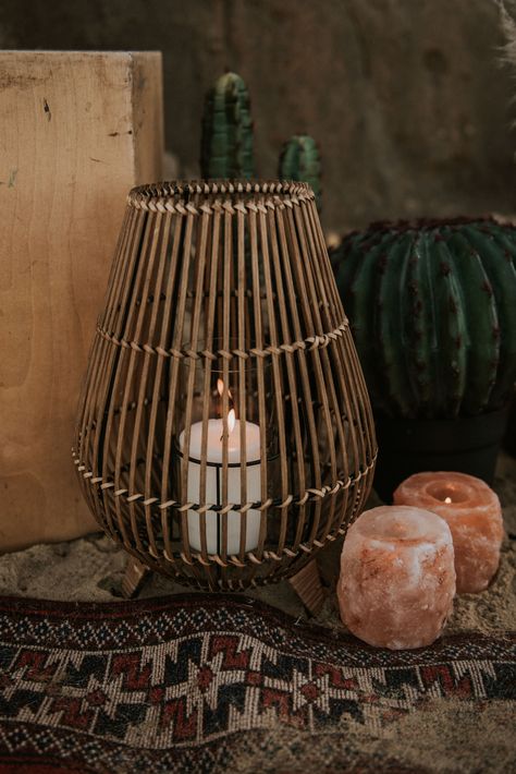 This shows a close up of a cane lantern with a pillar candle in it. The lantern is on a vintage rug. Surrounding the lantern are himalayan tea light candle holders, cactus plants and plinths. Cane Lanterns, Happisburgh Norfolk, Wildwood Flower, Cake Tables, Prop Hire, Norfolk, Seating Area, Pretty Things, Dried Flowers