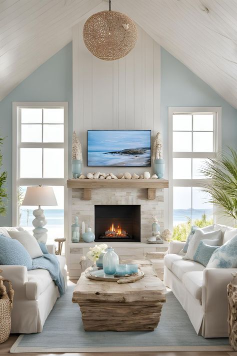 Coastal living room featuring an electric fireplace with a TV above and stylish wall storage, creating a harmonious decor. Electric Fireplace Ideas With Tv Coastal, Coastal Stone Fireplace Ideas, Beach Theme Fireplace, Beach Cottage Fireplace Ideas, Fireplace On Window Wall, Coastal Stone Fireplace, Beach House Tv Wall, Beach Fireplace Ideas, Coastal Electric Fireplace Ideas