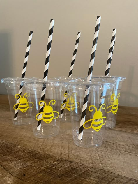 "One dozen party cups for your \"Honey Bee\" party theme * 9oz clear plastic disposable cups * vinyl honey bee decal * clear plastic lid * striped paper straw in black *sold by the dozen Matching items available in the \"Honey Bee Birthday\" Section! (links below) Monthly milestone banner: https://www.etsy.com/LittleJuniperDesigns/listing/888741201/honey-bee-birthday-monthly-milestone?utm_source=Copy&utm_medium=ListingManager&utm_campaign=Share&utm_term=so.lmsm&share_time=1623082711815 Cupcake t 1st Beeday Party, Bumble Bee Birthday Party Decorations, First Birthday Bee Theme, Bee Party Theme, Bee Birthday Decorations, Honey Bee Party, Honey Bee Birthday, Cups Vinyl, Bee Birthday Theme