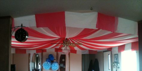 Circus Tent made out of plastic table cloths for Scarlets 4th birthday - just cut the table cloths in 3rds and use push pins to attach to the ceiling. Huge impact for only $10...... LOVED IT!!!! How To Make A Circus Tent, Streamer Circus Tent, Diy Big Top Circus Tent, Circus Vbs, Circus Tent Diy Plastic Tablecloth, Clown House, Black And White Circus Tent, Circus Tent With Table Cloth, Carnival Classroom