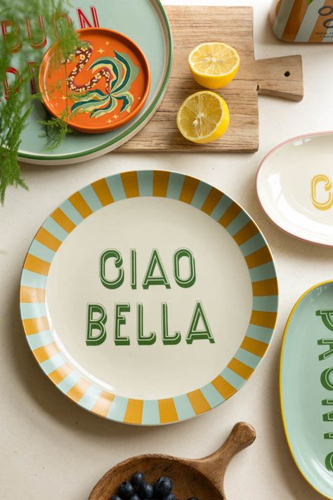 Welcome your guests in style with this fabulous art deco-inspired piece of serveware, which is a beautiful creation in mustard, mint and emerald green. We love the sentiment almost as much as the colours of this plate - together, they blend charm and sophistication to make every get-together feel a little more special. The elegant white is finished with a chic mustard yellow and green striped border, creating a stylish contrast that is both smart and playful. The sweet phrase, ‘Ciao Bella’, which means ‘Hello Beautiful’ in Italian, makes it easy to serve up compliments with every meal, too, welcoming your guests with traditional Italian warmth. Whether you’re serving up a quick snack or a full-on feast, dish out some love and make every bite a 'bella' experience. - Large White Ciao Bella P Mustard Yellow And Green, Rockett St George, Family Feast, Ciao Bella, Italian Ceramics, Pasta Bowls, Ceramic Plate, Quick Snacks, Yellow And Green