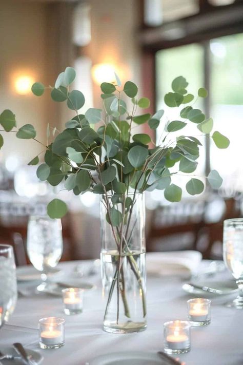 12 Beautiful Eucalyptus Centerpieces For Your Big Day • Eucalyptus Wedding Centrepiece, Wine Bottle Centerpieces Eucalyptus, Diy Eucalyptus Wedding Decor, Eucalyptus Wedding Vase, Eucalyptus Flower Centerpiece, Eucalyptus Wedding Ideas, Eucalyptus Table Numbers, Eucalyptus Floral Centerpiece, Fall Eucalyptus Centerpiece