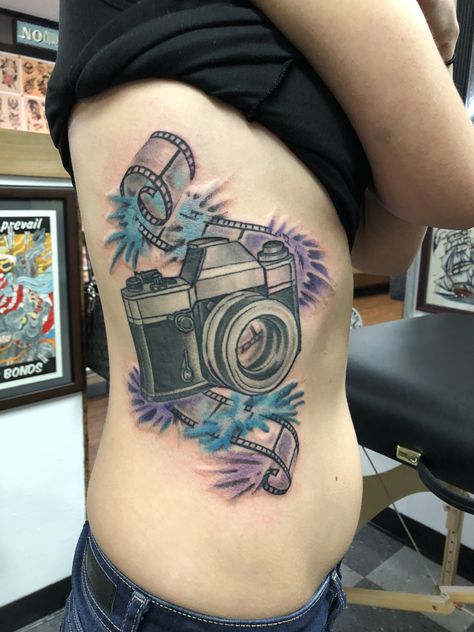 Water color camera tattoo I absolutely love photography. I got this done at #nokingstattoo The artist did an absolutely amazing job. He took my idea of a film strip with a camera with watercolor and made a masterpiece. Film Strip Tattoo, Camera Film Tattoo, Strip Tattoo, Tattoo Around Arm, Feather Outline, Camera Tattoos, Camera Tattoo, Tattoo Girls, My Idea