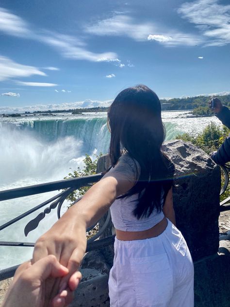 Standing by niagara falls holding photographers hand Niagara Falls Canada Photo Ideas, Niagara Falls Proposal, Niagara Falls Couple Pictures, Niagra Falls Outfits Summer, Niagara Falls Outfit Fall, Niagra Falls Photoshoot Ideas, Niagara Falls Photo Ideas, Niagra Falls Outfits, Niagara Falls Picture Ideas