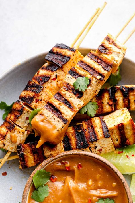 A grilled tofu skewer dipped in peanut sauce. Tofu Satay, Tofu Recipes Peanut Sauce, Tofu Skewers With Peanut Sauce, Tofu Satay Skewers, Thai Tofu Satay With Peanut Sauce, Chicken Skewers With Peanut Sauce, Tofu Satay With Peanut Sauce, Grilled Tofu Skewers, Satay Tofu