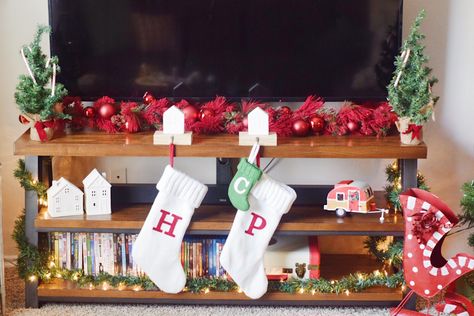 Christmas decorations on the TV stand Christmas Village On Tv Stand, Decorate Tv Stand For Christmas, Tv Unit Christmas Decor, Christmas Decor Ideas For Tv Stand, Christmas Tv Stand, Decorate Tv Stand, Tv Stand Christmas Decor, Tiny Candles, Tv Stand Decor