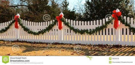 Photo about Plastic White Decorative Fence decorated with garland and red bows for the Holidays. Image of decorative, christmas, bows - 48200378 Christmas Garland Fence, Christmas Gate Decorations Outdoor, Fence Christmas Decorations, Door Painting Ideas, Sliding Gate Design, Outdoor Christmas Garland, Gate Design Modern, Gate For Stairs, Christmas Entry