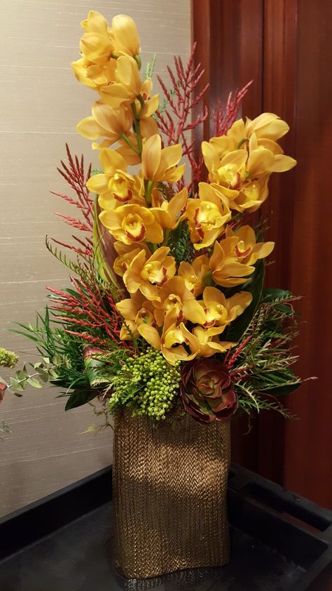 Cymbidium orchid arrangement Flower Arrangements With Orchids, Cymbidium Orchids Arrangement, Greenery Floral Arrangement, Rustic Flower Arrangements, Tall Flower Arrangements, Desk Flowers, Casket Flowers, Orchid Flower Arrangements, Tropical Floral Arrangements