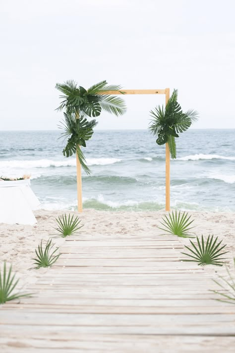 The couple got married on the beach in front of Long Beach Island Foundation of the Arts and Sciences with an arch made of palm fronds. | The Styled Bride Beach Wedding Arch, Jenna Lee, Tropical Wedding Decor, Wedding Venues Hawaii, Palm Wedding, Red Ginger, Beachy Wedding, Tropical Beach Wedding, Boho Beach Wedding