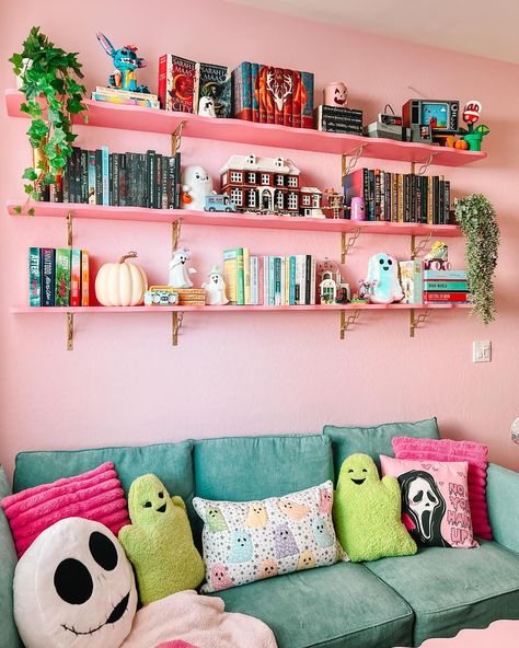 bet ya didn’t know i’d end up painting the shelves pink 😅🤭 we still need touch up some paint on the bottom of the shelves, but this was the last wall in my library that needed to be worked on & we basically finished it last night! my whole library is now officially done (for now lmao) & looks so fun from every angle 😭 spending time in here heals me 💞 its full of all of my favorite things & that’s so cool?? i have books, legos, a cozy gaming setup, puzzles, a comfy reading spot, a bookshelf... Bookshelf Maximalist, Maximalism Bookshelf, Maximalist Decor Bookshelf, Bright Color Bookshelf, Cute Bookshelf Ideas, Pink Bookshelf, Mid Century Bookshelf Pink, Cozy Gaming Setup, Wall Shelf Ideas