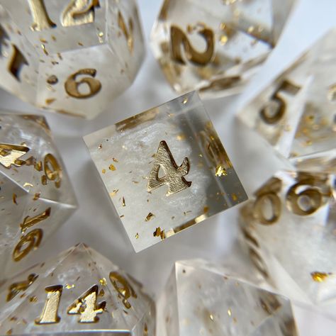 white pearlescent pigment inside a clear die with gold flake, inked in metallic gold, made by spellbound dice Gold And White Aesthetic, White Gold Aesthetic, White And Gold Aesthetic, Gold Dice Aesthetic, Dnd Aesthetic Dice, Dungeons And Dragons Aesthetic Dice, Studying Stationary, Dnd Dice Liquid Core, Crystal Dice