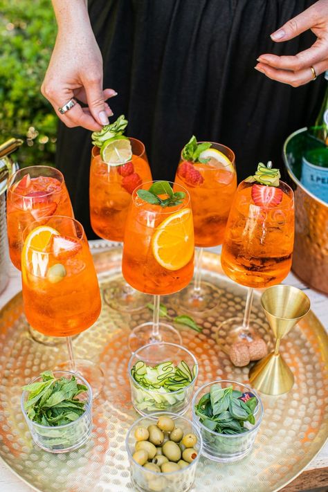 Everyone loves an Aperol spritz, but this Aperol Spritz Bar is the perfect way to appease all of your guests and let them have a hand in creating their perfect cocktail! Make a beautiful presentation of the ingredients, set out a recipe card, and let your guests go to town by mixing their preferred proportions and garnishes. This is the perfect way to serve drinks at a summer party! Aperol Spritz Decoration, Aperol Spritz Aesthetic Party, Summer Party Cocktails, Aperol Spritz Bar, Spritz Bar, Cocktails To Make At Home, Aperol Spritz Recipe, Grilled Peach Salad, Best Summer Cocktails