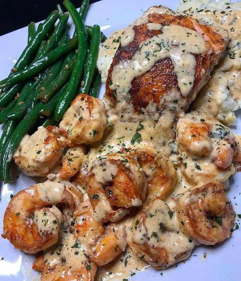 A flavorful and hearty meal, this Cajun shrimp and salmon is cooked to perfection and served with a buttery garlic cream sauce, creamy mashed potatoes and garlic sautéed green beans. Perfect for a dinner with friends or family Mashed Potatoes And Green Beans, Arabisk Mad, Potatoes And Green Beans, Seafood Dish Recipes, Salmon And Shrimp, Garlic Cream Sauce, Gourmet Dinner, Shrimp Recipes Easy, Pescatarian Recipes