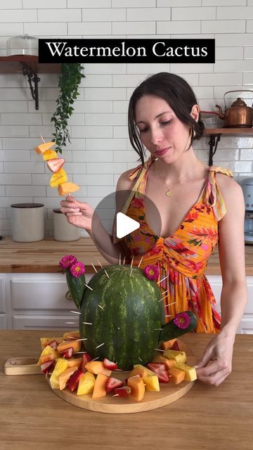 Sheri Wilson on Instagram: "Watermelon Cactus! 🌵such a fun centerpiece and only takes a few minutes to put together!   Oasis Dress 🧡 @jessakae   1. Cut off the bottom of a watermelon and set upright on a serving platter.  2. Cut off the ends of two small cucumbers diagonally, then attach to the watermelon with toothpicks. 3. Poke toothpicks all over the watermelon for the cactus spines. 4. Add a few fresh flowers with toothpicks. 5. Add fruit skewers around the bottom.  #summerdecor #diy #summercenterpiece #summerideas #fruit #fruitarrangement #fruitplatter" Watermelon Cactus, Cactus Dessert, Sheri Wilson, Summer Desert, Desert Food, Summer Centerpieces, Small Cucumber, Fruit Skewers, Fruit Arrangements