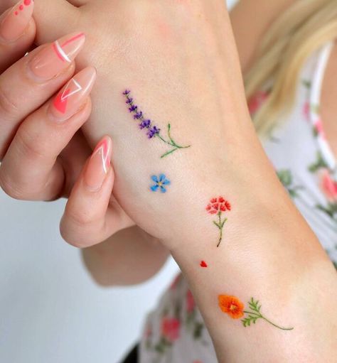 Many colorful small flowers tattoos on the hand Colorful Tatoos Woman, Tiny Color Tattoos, Wrist Flower Tattoo, Small Color Tattoo, Small Colorful Tattoos, Hand And Finger Tattoos, Palm Tattoos, Handpoke Tattoo, Small Flower Tattoos