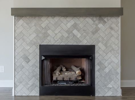 This fireplace surround features subway tile from Daltile's limestone collection installed in a beautiful herringbone pattern. Grey Herringbone Fireplace, Herringbone Tile Fireplace Surround, Herringbone Fireplace Surround, Herringbone Tile Fireplace, Tiled Fireplace Wall, Tile Around Fireplace, Ames Tile, Herringbone Fireplace, Farmhouse Mantle Decor