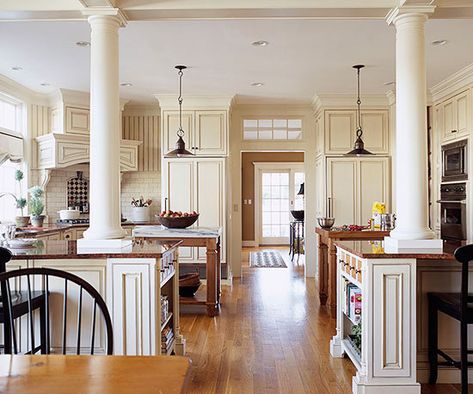 This kitchen is right in the middle of the home's main traffic flow. To keep passersby out of the way, the owners divided the kitchen with two islands and left ample room for a walkway in the center. This layout creates dedicated work zones on each side of the kitchen. Peninsulas that support the Colonial-style columns offer seating where friends and family can gather outside the kitchen but still chat with the cook. Kitchen Island With Columns, Small Open Kitchens, Open Kitchen Layouts, Open Floor Plan Kitchen, Large Open Kitchens, Kitchen Conversion, Loft Kitchen, Industrial Style Kitchen, Open Concept Home