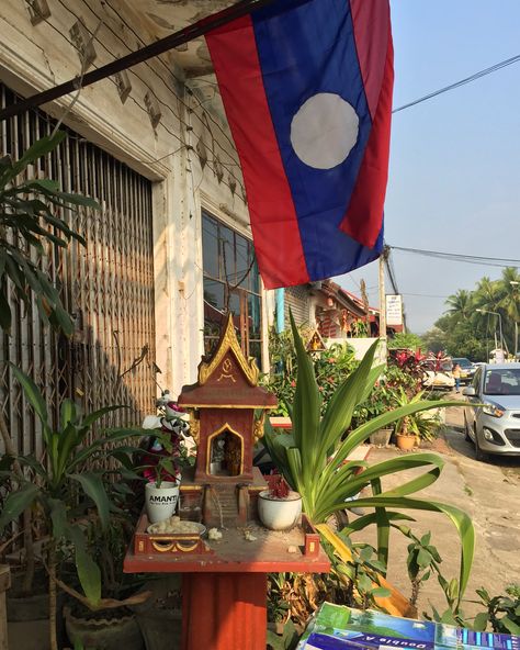 Spirit house with Lao flag Laos Aesthetic, Lao Culture, Laos Flag, Cambodian Flag, Laos Culture, Spirit House, Gap Year Travel, Laos Travel, Luang Prabang