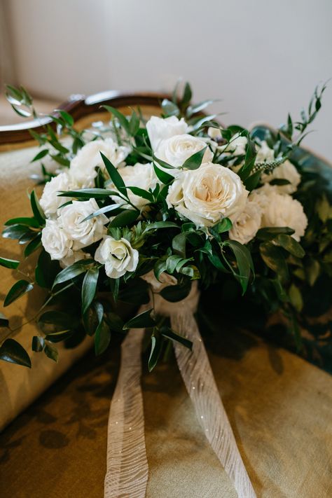 Bouquet by Soiree Floral Designs. Italian ruscus and nagi greenery, playa roses, ranunculus, white majolicas, anemones, lisianthus (no buds), white veronica. Scrap piece of Bride's dress from hemming used as ribbon. Photo by Valerie Lendvay. Nagi Greenery, White Rose And Italian Ruscus Bouquet, Italian Ruscus Wedding Bouquet, White Rose Bouquet With Greenery, Italian Bridal Bouquet, Italian Ruscus Bouquet, Ivory Rose Bouquet, Bouquet Dress, Italian Ruscus