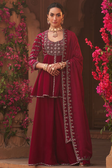 Magenta peplum short kurta in velvet base with metallic, salli, mukaish, dabka, nalki and zari hand embellishments. It is paired with sharara pants and organza embellished dupatta. for a wedding, sangeet or engagement ceremony.  #Perniaspopupshop #womenswear #ethnic #whatiworewastrending #ppuslove #shararaset #velvet #organza #dabkaembroidery #handwork  #weddingwear #engagement #festivewear Velvet Sharara, Magenta Velvet, Kurta And Sharara, Velvet Kurta, Embroidered Border, Draped Skirt, Dupion Silk, Sharara Set, Zari Work