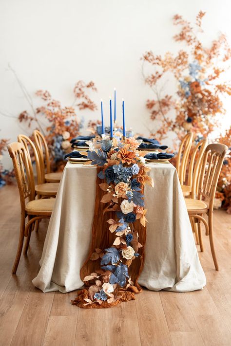 Indulge your free spirit with Ling's Russet Orange & Denim Blue Collection. Warm Orange collides with shades of soft and rich denim blue, creating a rustic palette ideal for fall or barn weddings. Save time on your wedding journey with premade floral arrangements, like bouquets, centerpieces, and arch decor, or exp Marigold And Blue Wedding, Navy And Rust Wedding Table Decor, Country Centerpieces Wedding, Long Wedding Table Centerpieces, Navy Blue And Terracotta Wedding Centerpieces, June Wedding Centerpieces, Fall Wedding With Blue, Terracotta And Dusty Blue Wedding, Blue And Gold Table Decor