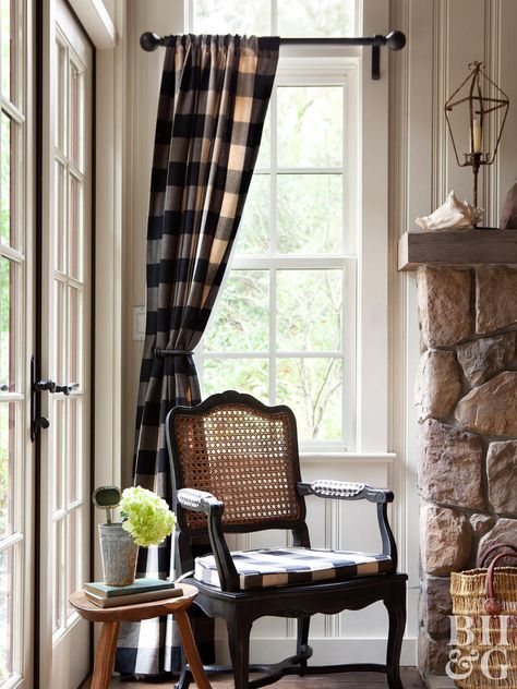 We couldn’t talk about rustic window treatments without mentioning the ever-dependable plaid. Give plaid curtains a modern update in navy or black buffalo check that’ll easily coordinate with other colors and withstand the test of time. Use them as rustic cabin curtains or bring country style to your everyday living room. For a cohesive look, use bits of the fabric elsewhere around the room. Try it on a throw pillow or upholstered cushion like the traditional cane back chair shown here. Cabin Curtains, Rustic Window Treatments, Farmhouse Window Treatments, Plaid Curtains, Dining Room Curtains, Window Treatments Living Room, Rustic Window, Farmhouse Windows, Rustic Dining Room