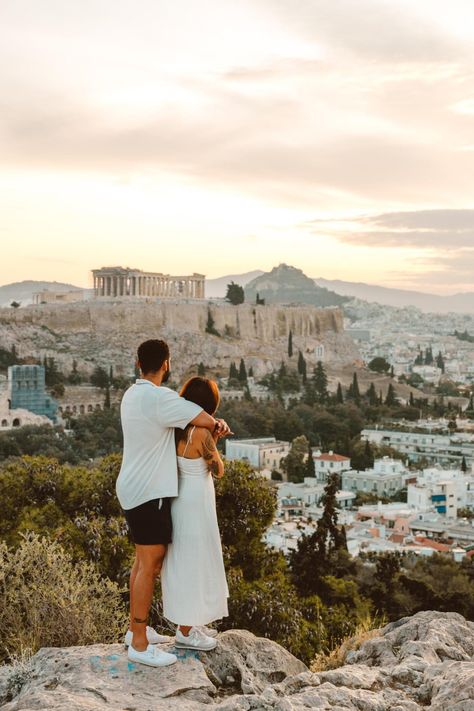 a couple hold hands on Philopoppus Hill, watching the sun rise over the Acropolis and the city of Athens, Greece. Athens Couple Photos, Athens Photography, Greece Pics, Relationship Vision Board, Greece Cruise, Greece Honeymoon, Athens City, Italy Honeymoon, The Acropolis