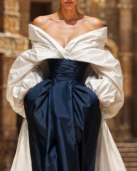 Unveiling the couture taffeta moulage dress, a voluminous off-white gown with an off-shoulder top,a pleated bodice, and a striking blue opal skirt with pockets. Smoothed off with a taffeta over-skirt train for a regal, elegant silhouette. #saiidkobeisy #hautecouture #FW2425 Moulage Dress, Saiid Kobeisy, Old Fashion Dresses, Taffeta Dress, Pleated Bodice, Wedding Dress Couture, White Gowns, Skirt With Pockets, Fashion Costume