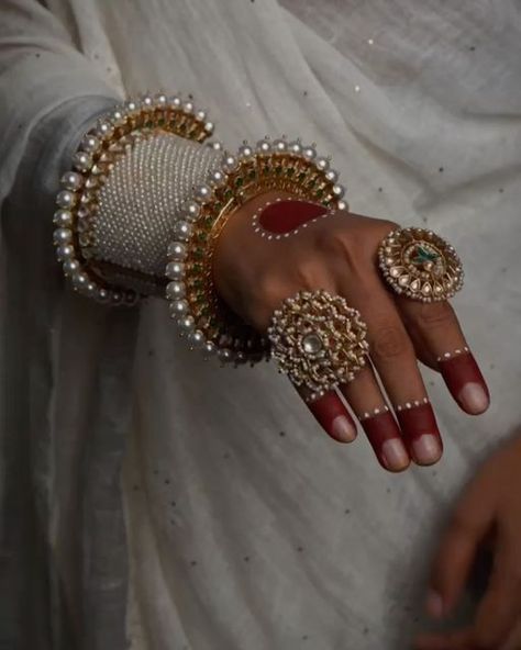 Surabhi didwania on Instagram: "Elevate your style with our exquisite hand stack, a timeless tribute to cultural opulence. Adorn your wrist with our uniquely shaped, intricately detailed silver bangles & kada, handcrafted with precision by our master craftsmen. Featuring the royal pearls design on kada and exquisite meenakari on gold-toned pacheli, each piece looks absolutely adorable. Elevate your elegance with these timeless treasures. Each piece exudes elegance and sophistication, ensuring you make a statement wherever you go. Let the timeless beauty of silver capture every eye.  Adrta : S16682310 Abheri : S17739964 Oversize ring with rubies : S9362261 Floral Ring : S16359340  Shop now on www.mymotifs.com We deliver worldwide 🌍🌎✈️  #finejewellery #gemstones #silverjewellery #indianjew Hand Stack, Hand Chain Jewelry, Diy Fabric Jewellery, Fabric Jewellery, Floral Ring, Pearl Design, Fancy Jewellery, Hand Chain, Chain Jewelry