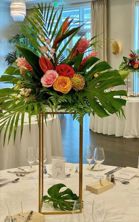 Tall Tropical Centerpiece on gold stand Palm Frond Decor Wedding, Tropical Arrangements Centerpieces, Tall Tropical Centerpieces Wedding, Hawaiian Flower Centerpieces, Tropical Lantern Centerpieces, Birds Of Paradise Centerpiece, Diy Tropical Centerpieces Wedding, Wedding Palm Leaves, Birds Of Paradise Wedding Centerpieces