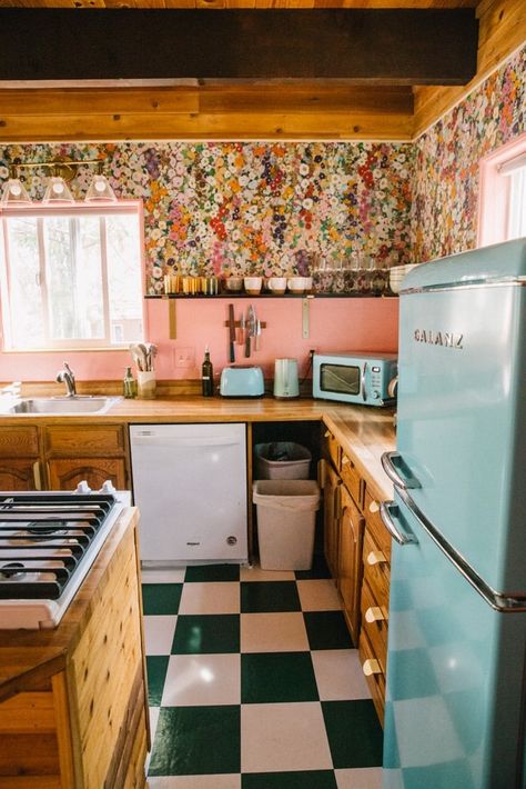 My pink kitchen makeover - from drape to colorful and all without a major renovation! I loved my retro kitchen and turned it into a cool pink kitchen with floral wallpaper. I kept my wood cabinets instead of doing pink cabinets but did pink walls and pink floral wallpaper. It was cheaper to not do pink subway tiles and instead use paint and retro appliances to add color to my shabby pink kitchen. 70s Pink Kitchen, Pink And Wood Kitchen, Floral Backsplash Kitchen, Pink Tiles Kitchen, Pink Backsplash Kitchen, Pink And Yellow Kitchen, Southwest Kitchen Ideas, Pink And Green Kitchen, Pink Kitchen Walls