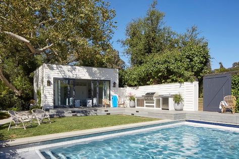 An in-ground swimming pool is fixed in front of a shiplap siding pool house accented with sliding glass doors. Outdoor Design Modern, Bbq Wall, City Backyard, Pool House Cabana, Squash Court, Contemporary Colonial, Ranch Renovation, Shiplap Siding, Backyard Escape