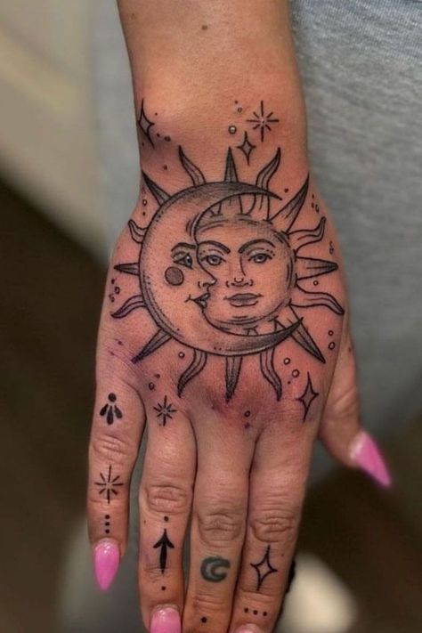 The sun and moon hand tattoo is a stunning tattoo idea for women who love celestial designs. This small tattoo for female hands is a perfect blend of balance and harmony, representing duality in a delicate, meaningful way. Hand Spiritual Tattoo, Spiritual Tattoos Hand, Top Of Hand Tattoos For Women Unique, Moon And Sun Hand Tattoo, Women Hand Tattoo Ideas Unique, Cover Up Tattoos Hand, Moon Hand Tattoos For Women, Arm And Hand Tattoos For Women, Let Them Tattoo Ideas On Hand