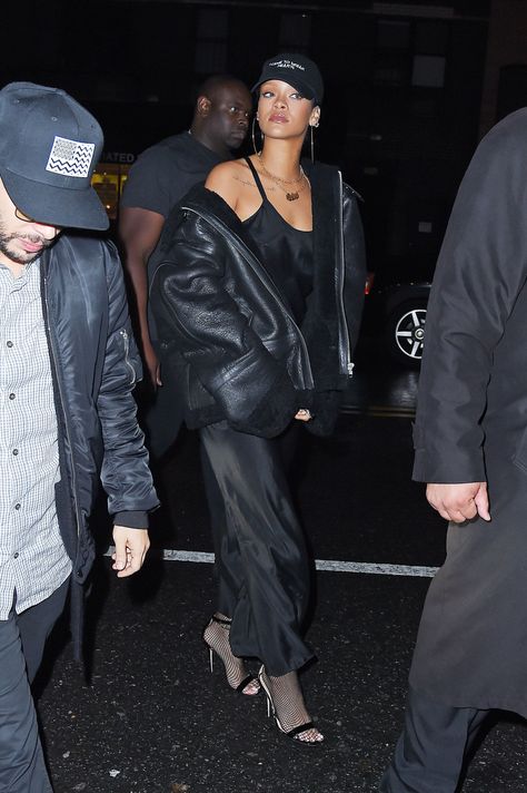 In NYC wearing a black slip dress and leather jacket with Manolo Blahnik sandals and a baseball cap.    - ELLE.com Cap Outfit Black Woman, Rihanna Style 2015, Black Shearling Jacket, Rihanna Street Style, Looks Rihanna, Rihanna Outfits, Rihanna Looks, Cap Outfit, Rihanna Style