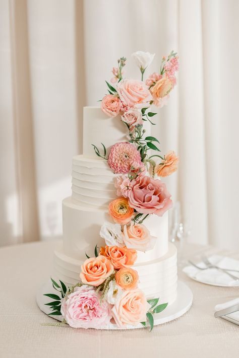 four tiered wedding cake adorned with peach and pink florals and greenery Peach Wedding Cake Simple, Wedding Cake Pink And Orange, Peach Flower Wedding Cake, Pink Peach Wedding Theme, Spring Floral Wedding Cake, Wedding Cake Pastel Flowers, Teal Peach Wedding, Wedding Cake Pastel, Peach And Blush Wedding