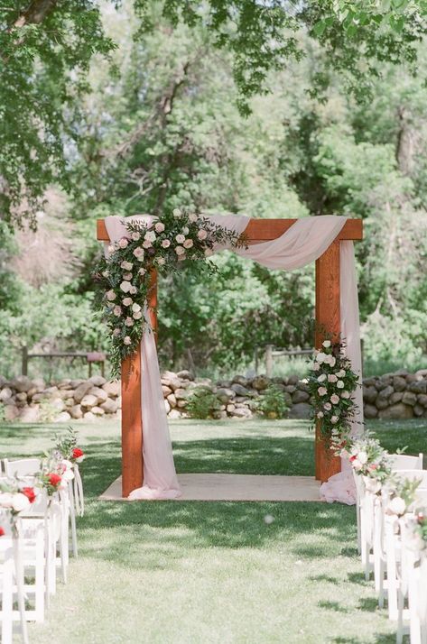 Sheridan, WY destination wedding florist draped pale pink fabric on this large wedding arch and created flowers in blush tones with roses, ruscus and eucalyptus at the Brinton Museum for a June wedding in Burgundy and Blush with navy accents. Wedding arch, arbor with two floral pieces in asymmetrical design Gold Wedding Ceremony Decor, Wedding Ceremony Arbor, Ceremony Arch Flowers, Blush And Burgundy Wedding, Outside Wedding Ceremonies, Wedding Arbors, Wedding Alters, Wedding Arbor, Blush Wedding Flowers