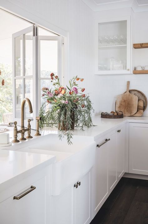 The white country shaker-style kitchen in this Queensland homestead is lifted by lots of light and fresh flowers. Australian Country Kitchen, Queenslander Kitchen Renovation, Country Coastal Kitchen, Country Style Homes Interior, White Queenslander, Federation Kitchen, White Farm Kitchen, Queenslander Interior, Queenslander Kitchen