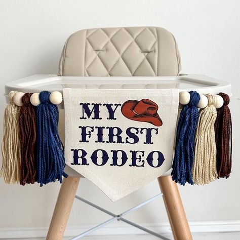 Round up an unforgettable celebration with our western birthday party decorations! Perfect for a cowboy 1st birthday, our navy My First Rodeo highchair banner sets the stage for a fun-filled event. Your little cowboy will love the authentic cowboy hat, adding a touch of the Wild West to the party. Embrace the wild one theme decor with our vibrant 1st Rodeo sign. Saddle up and make your child's first birthday a wild adventure! You have the option to add the ONE gold glitter cake topper.  Add a matching BALLOON TOWER! https://www.etsy.com/listing/1771082333 Add a matching CUSTOM BANNER from our sister store! https://www.etsy.com/listing/1591437932 CHANGE YOUR TASSEL COLORS HERE: https://www.etsy.com/listing/1677655457 WARNING: CHOKING HAZARD. This is not a toy. Small parts, adult supervision