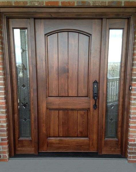 Leaded glass sidelights add a distinctive flair to this select alder door unit with arched top rail and raised panels with v-grooves.  Glass by Scottish Stained Glass. French Country Doors Entrance, Tradition House, Craftsman Style Front Doors, House Entry Doors, Door Renovation, Exterior Doors With Sidelights, Brown Front Doors, Cabin Storage, Entry Door With Sidelights