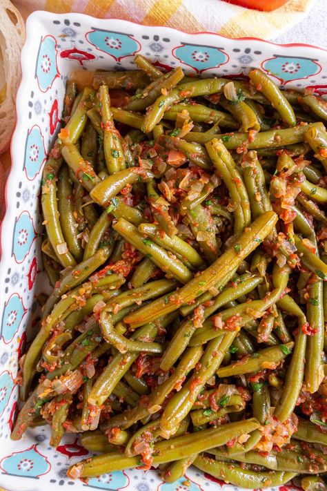 Fasolakia (Greek stewed green beans) is a delicious vegetarian/vegan main course or side dish. With only 6 ingredients plus seasonings, this simple dish builds incredible slow-cooked flavor in less than an hour from start to finish. Green Beans Greek Style, Mediterranean Green Beans, Greek Vegetables Side, Fasolakia Recipe, Stewed Green Beans, Mediterranean Sides, Good Green Bean Recipe, Best Green Beans, Greek Green Beans