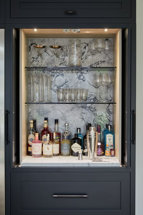 Here's the inside of a bespoke bar unit with pocket doors that fold right back into the cupboard when in use. The backsplash is in Moonrock Quartzite to match the work surfaces in the kitchen and combined with the glass shelves and lighting, create a sophisticated and luxurious drinks area. #kitchendesigns #luxurykitchen #kitchenextension Bourbon Cabinet, Drinks Area, Built In Bar Cabinet, Drinks Cabinets, Colonial Renovation, Dark Kitchens, Luxury Kitchen Designs, Room Cupboard, Reno Kitchen