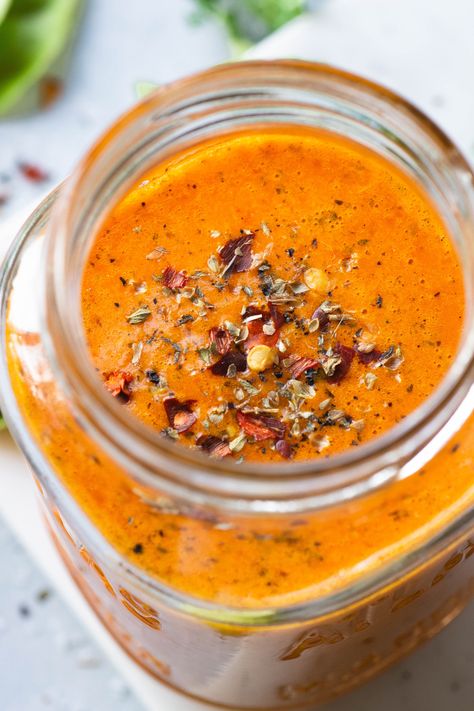 Close up view of the inside of a jar of bright orange roasted red pepper dressing Spicy Red Pepper Dressing, Roasted Red Pepper Vinaigrette, Roasted Red Pepper Salad Dressing, Roasted Bell Pepper Sauce, Red Pepper Salad Dressing, Roasted Red Pepper Dressing, Healthy Green Salad, Red Pepper Dressing, Red Pepper Sauce Recipe