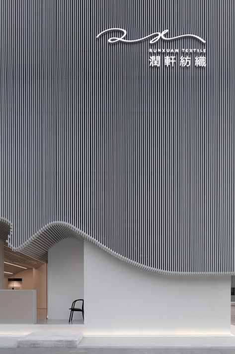 For a textile company in Foshan, China, Rationale International – Masanori Design Studio devised an exterior that recreates the symmetry of yarn on a loom using slender white-toned aluminum bars. Retail Facade, Shop Facade, Storefront Design, Interior Minimalista, Building Facade, Facade Architecture, Facade Design, Commercial Design, Facades